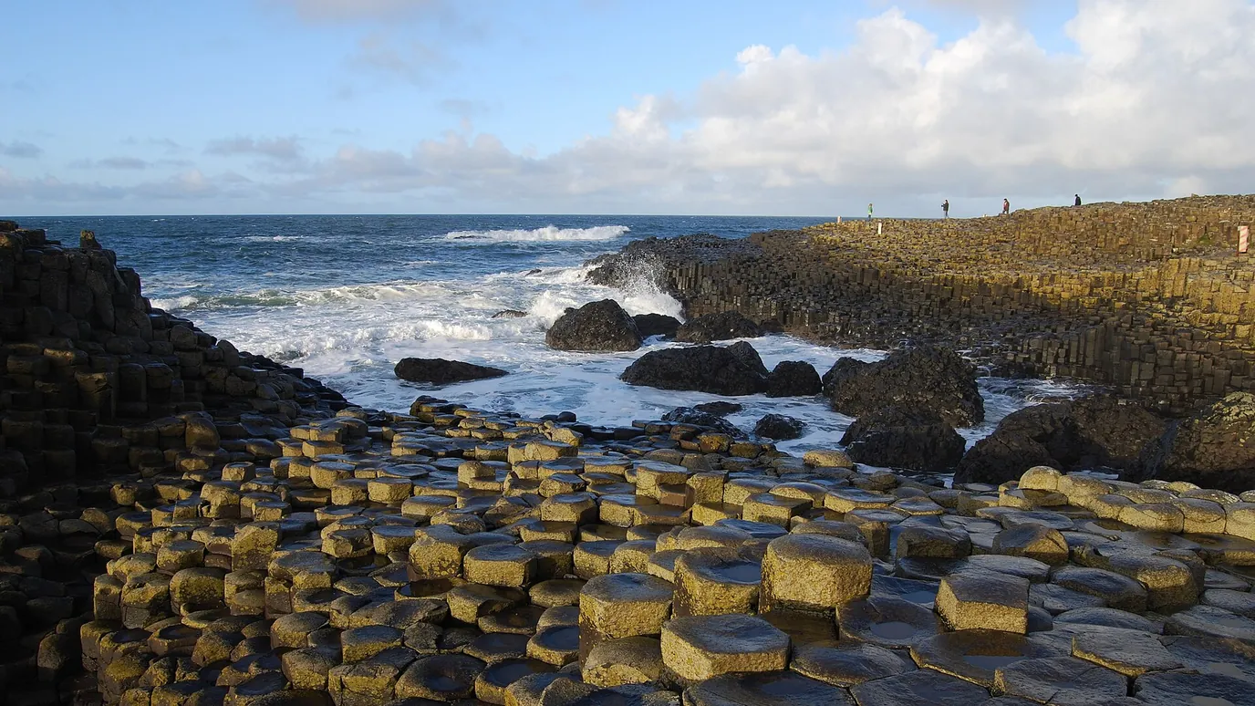 Dark basalt columns at the Giant's Causeway, with waves breaking beyond.